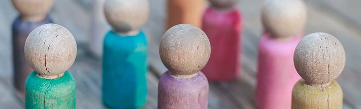 Bunte Holzspielfiguren in einer Gruppe